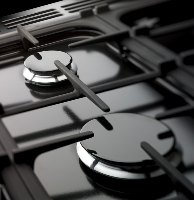 Detailaufnahme von zwei Gaskochfeldern eines modernen Herdes mit glänzender Oberfläche und stabilen Rosten