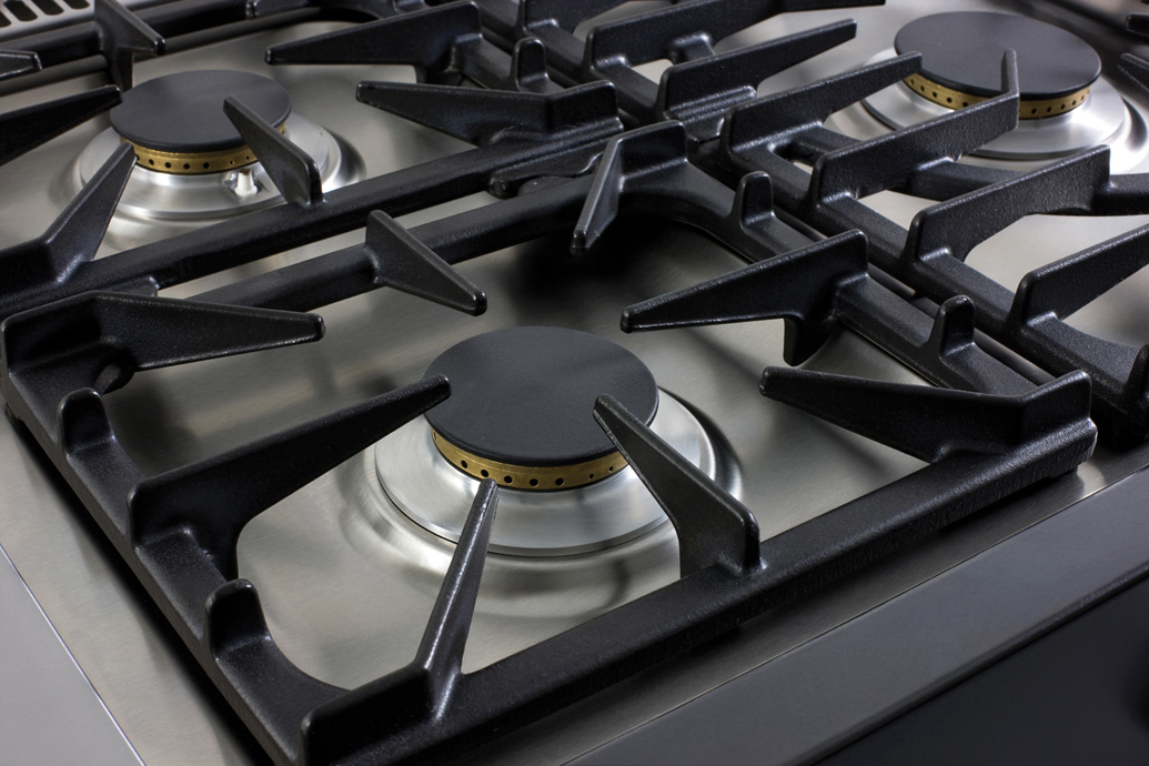 Nahaufnahme eines modernen Edelstahl-Gaskochfelds mit drei Brennern und robusten Gusseisenrosten