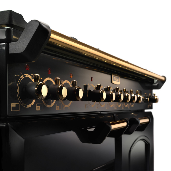 Nahaufnahme eines hochwertigen schwarzen Herdes mit edlen, goldenen Drehknöpfen und stilvollen Details