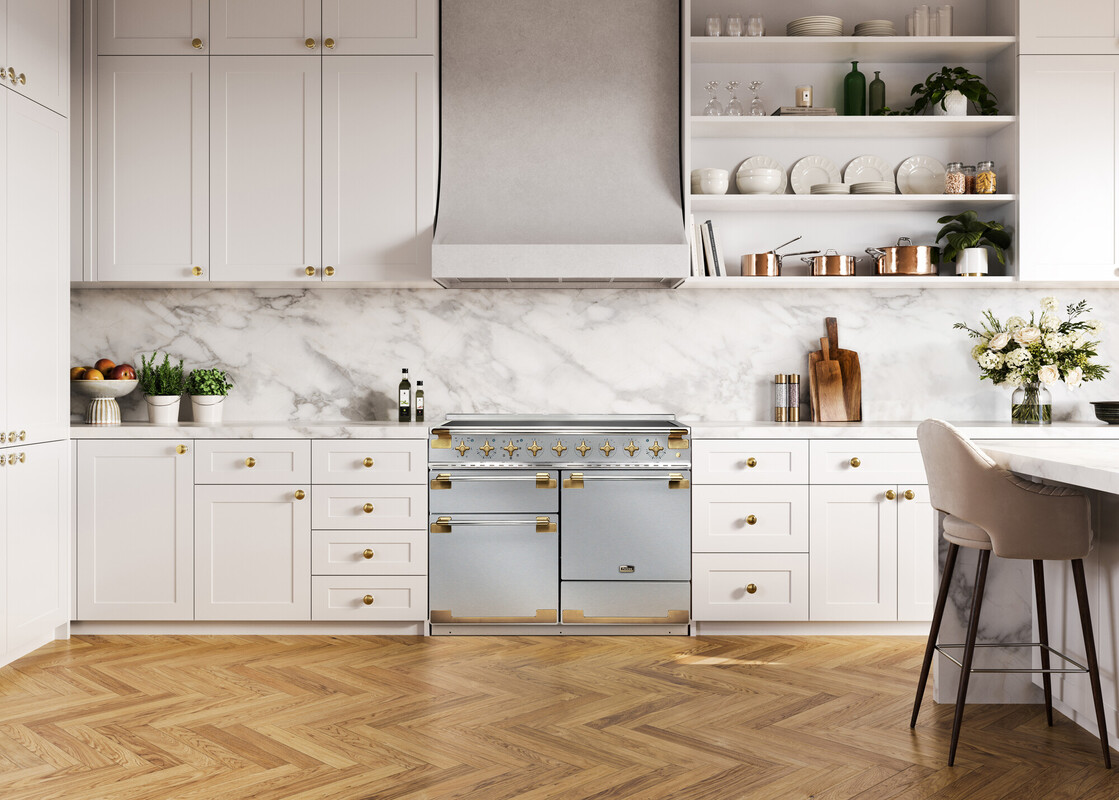 Elegante, helle Küche mit weißen Schränken, Marmorwand, goldenen Akzenten und einem hochwertigen Herd. Dekorative Elemente wie Kräutertöpfe, Blumen und Küchenutensilien sorgen für einen stilvollen Look.