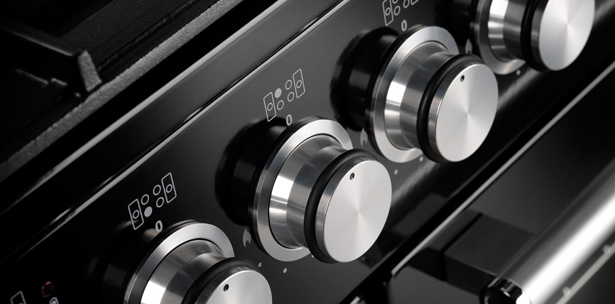 Nahaufnahme von silbernen Edelstahl-Drehknöpfen an einem modernen Herd oder Backofen