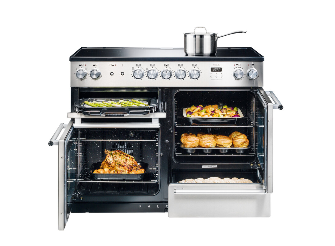 Großer Edelstahl-Backofen mit zwei geöffneten Türen, mehreren Speisen wie Hähnchen, Gemüse, Gebäck und einem Kochtopf auf dem Cerankochfeld