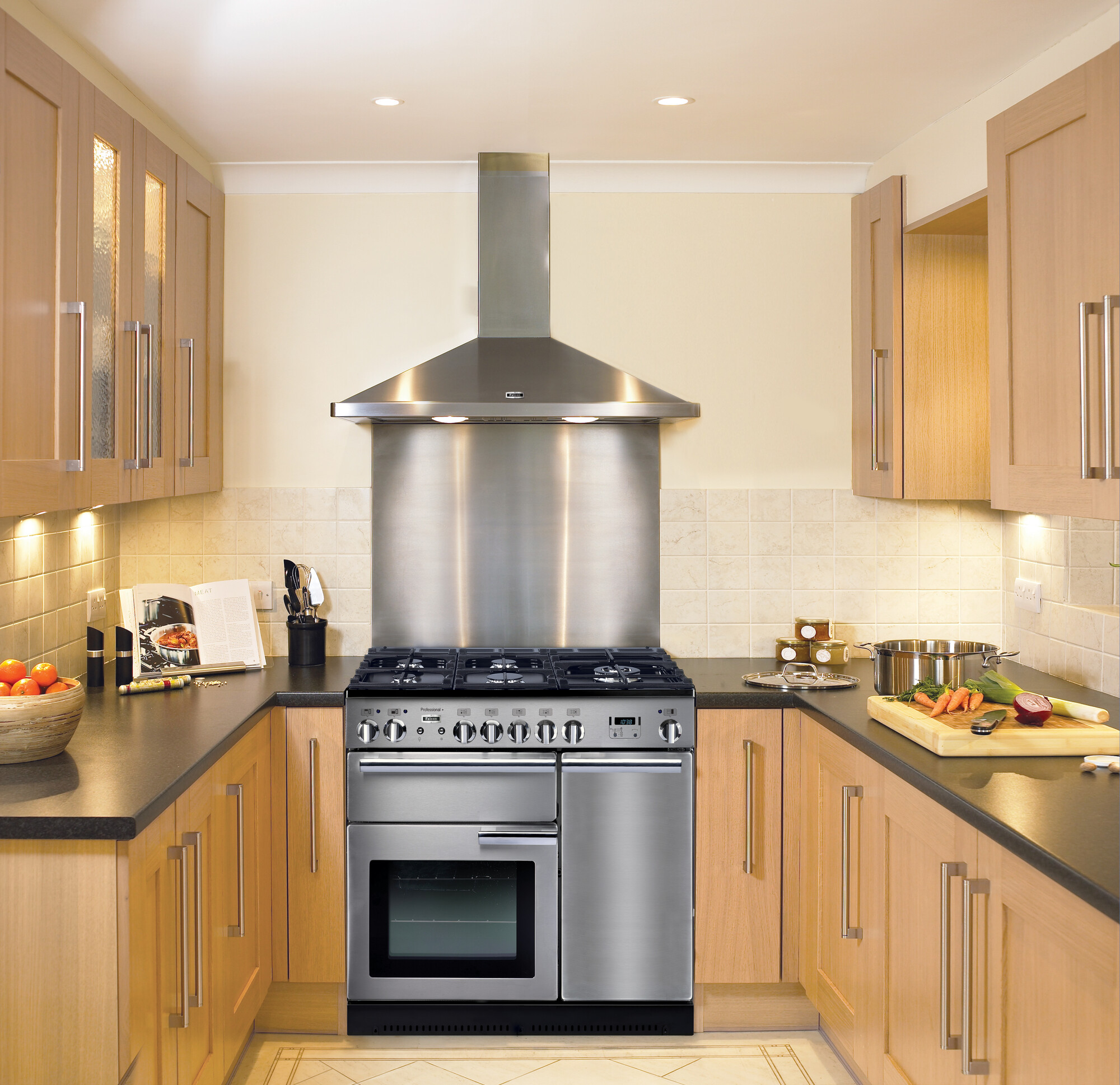 Geräumige Einbauküche mit Edelstahl-Herd, Dunstabzugshaube, Holzmöbeln und Schneidebrett mit frischem Gemüse auf der Arbeitsplatte