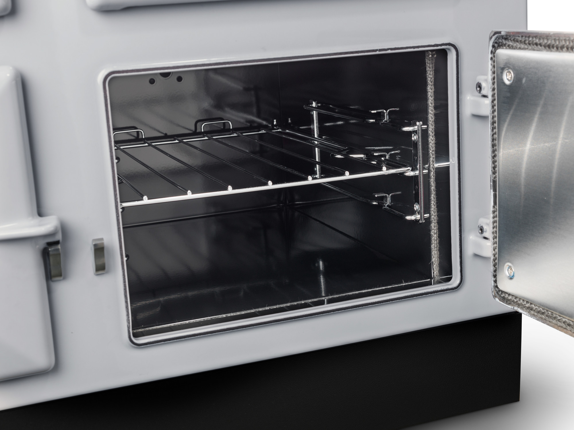 Innenansicht eines geöffneten Backofens mit Gitterrost und geöffneter Tür, geeignet für die Zubereitung von Speisen