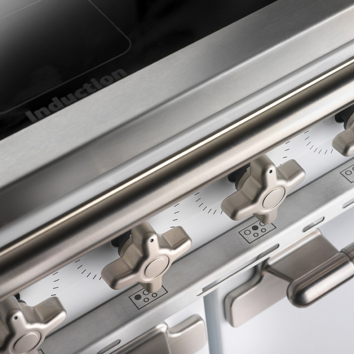 Nahaufnahme eines Induktionsherds mit mehreren Edelstahl-Drehknöpfen und robustem Design