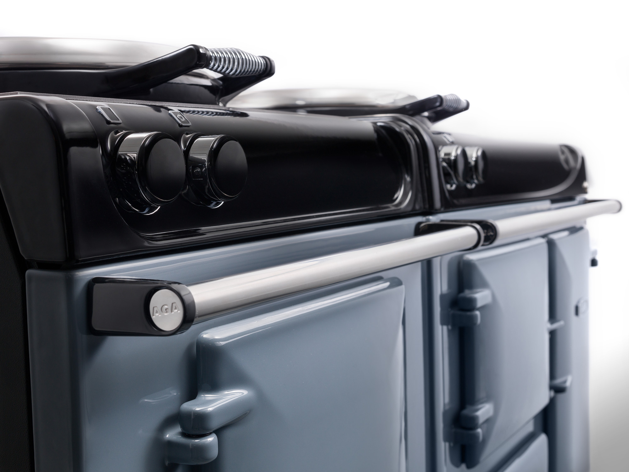 Detailansicht eines hochwertigen AGA Herdes mit hellblauen Türen und schwarzen Bedienelementen