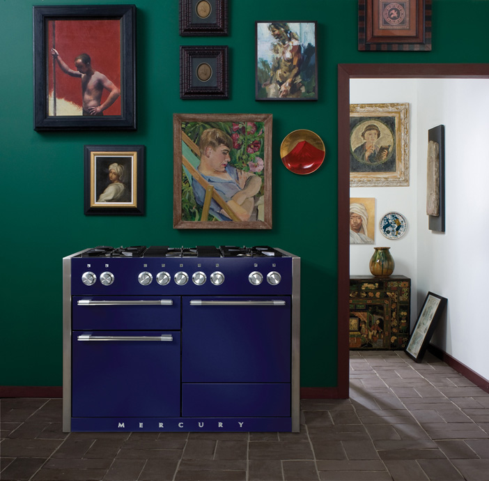 Moderner Gasherd in Blau von MERCURY steht vor einer grünen Wand mit mehreren gerahmten Gemälden, daneben Blick in einen geschmackvoll dekorierten Raum