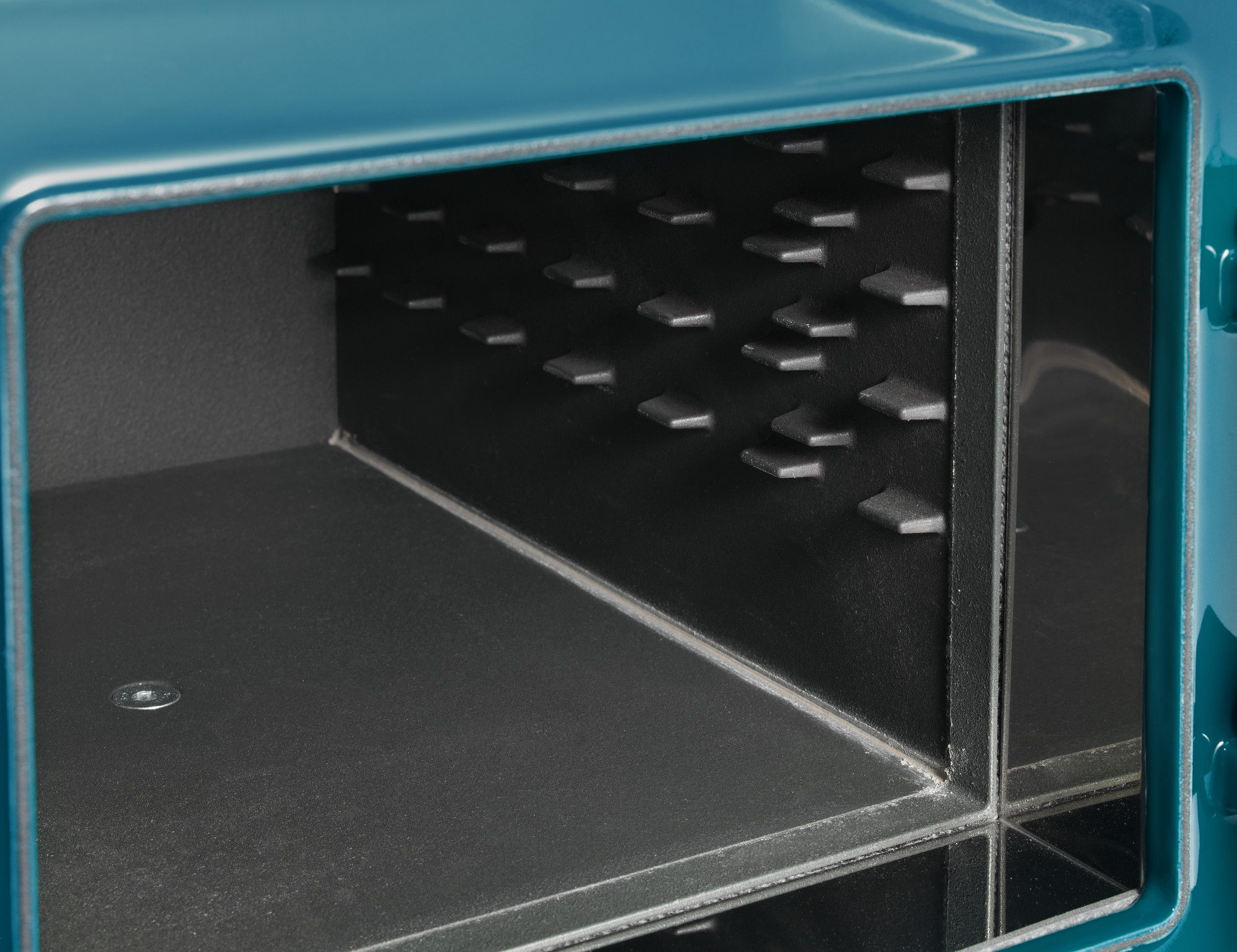 Detailansicht des Innenraums eines blauen Tresors mit speziell geformten Sicherheitselementen an der Wand