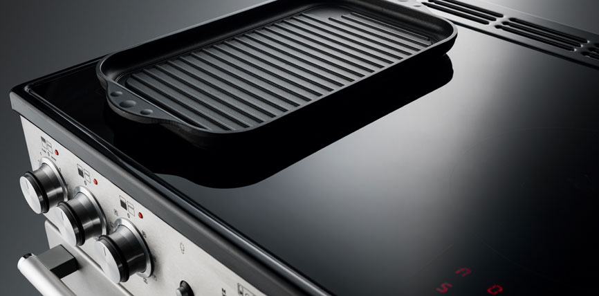 Schwarzes Induktionskochfeld mit darauf platzierter Grillplatte aus Gusseisen in einer modernen Küche