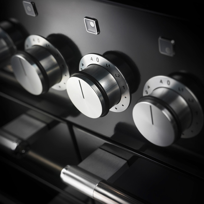 Detailaufnahme von Edelstahl-Drehknöpfen und Bedienfeld eines modernen Backofens
