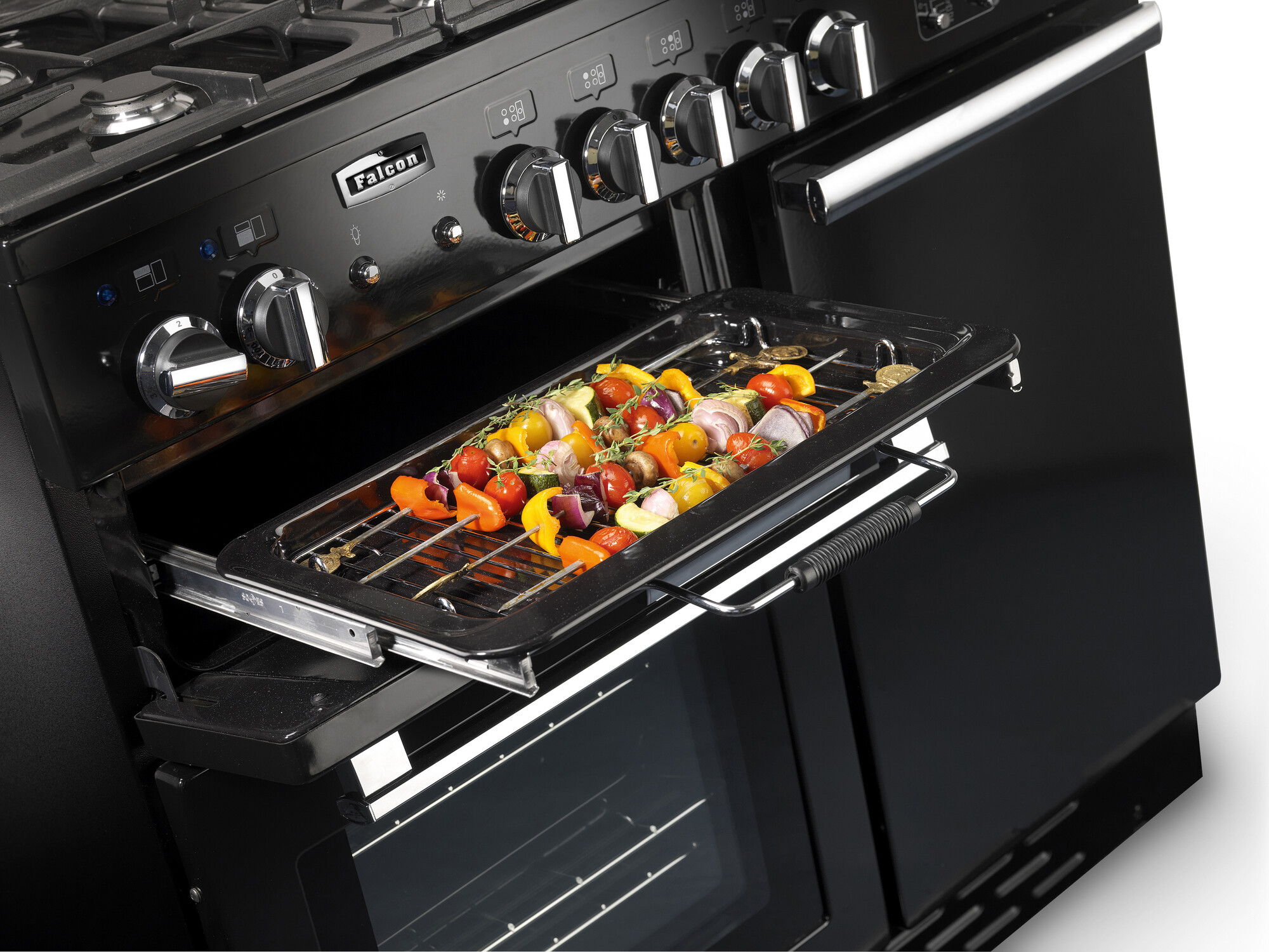 Ein moderner schwarzer Herd mit geöffnetem Backofen. Im Ofen befinden sich Gemüsespieße auf einem Grillrost, bereit zum Garen.