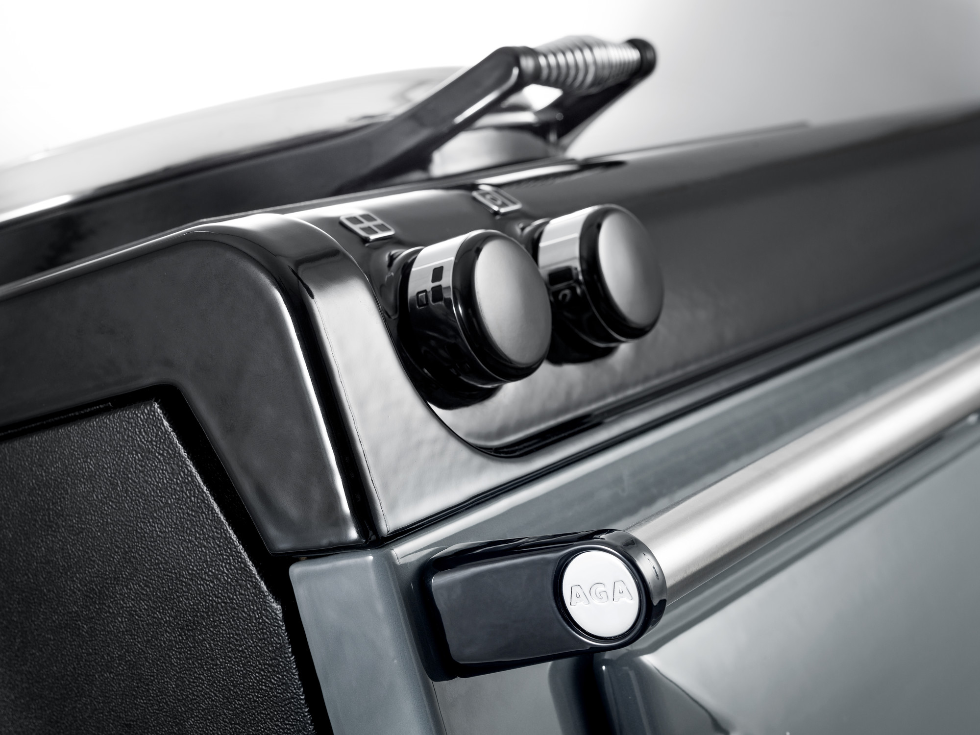 Nahaufnahme von Bedienelementen und Griff eines schwarzen AGA Küchenherdes